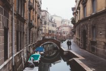 Vista trasera de pareja paseando a lo largo de la orilla del canal, Venecia, Italia - foto de stock