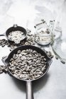 Top view of sunflower seeds in pans and jars — Stock Photo