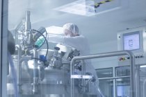 Travailleur exploitant un équipement de production pharmaceutique dans une usine pharmaceutique — Photo de stock