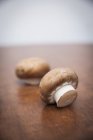 Two fresh mushrooms on wooden table — Stock Photo