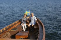 Casal sentado em barco no oceano azul — Fotografia de Stock