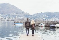 Задній вид молода пара на пристані погляд на Комо, Італія — стокове фото