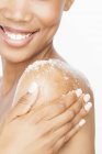 Cropped view of woman exfoliating bare shoulder — Stock Photo