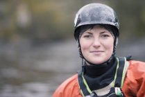 Portrait of young female kayaker in watersports helmet — Stock Photo