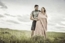 Giovane donna felice avvolta in una coperta con fidanzato nel paesaggio, Cody, Wyoming, Stati Uniti d'America — Foto stock