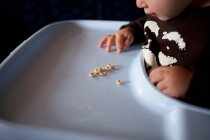 Criança em cadeira alta com cereais de pequeno-almoço — Fotografia de Stock
