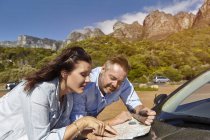 Casal inclinado no capô do carro, olhando para o mapa, Cidade do Cabo — Fotografia de Stock