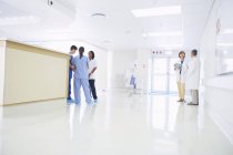 Врачи и медсестры разговаривают на сестринском посту в больнице — стоковое фото