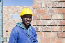 Portrait of builder wearing hard hat looking at camera smiling — Stock Photo