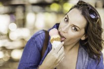 Frau isst Eistüte und blickt in Kamera — Stockfoto