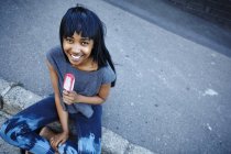 Retrato de mulher jovem, ao ar livre, comendo gelado, vista elevada — Fotografia de Stock