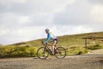 Side view of Cyclist riding on gravel road — Stock Photo