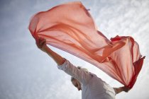 Mature woman outdoors, holding scarf behind her, low angle view — Stock Photo