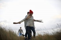 Young adults collecting driftwood in coastal dunes — Stock Photo