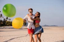 Young couple on beach playing with balloons, Koh Samui, Thailand — Stock Photo