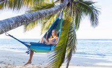 Junge Frau in der Hängematte unter Palmen, Dominikanische Republik, Karibik — Stockfoto