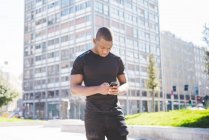 Молодий чоловік використовує смартфон на відкритому повітрі — стокове фото