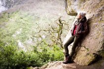 Woman leaning against rock looking away at view, Bruniquel, France — Stock Photo