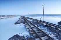 Vía del tren de mercancías, Haixi, Chaka Salt Lake, provincia de Qinghai, China - foto de stock