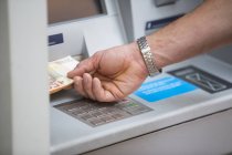 Mann hebt Bargeld am Geldautomaten ab — Stockfoto