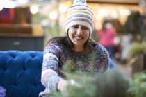 Mature woman wearing knit hat drinking red wine at sidewalk cafe — Stock Photo