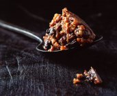 Spoonful of Christmas pudding on wooden surface — Stock Photo