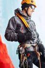 Льодовий альпініст з обладнанням для скелелазіння дивиться геть усміхнений — стокове фото