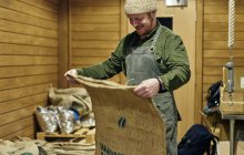 Dono masculino café dobrável saco de grãos de café na sala de armazenamento — Fotografia de Stock