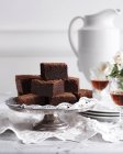 Pila di brownie al cioccolato su cakestand con bicchieri di vino — Foto stock