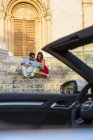 Jovem casal com conversível sentado na escada da igreja olhando para o mapa, Calvia, Maiorca, Espanha — Fotografia de Stock