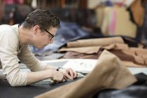 Homem de corte de couro com faca de utilidade em fabricantes de jaqueta de couro — Fotografia de Stock