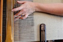 Руки молодой женщины, использующей ткацкий станок — стоковое фото