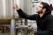 Trabalhador em cervejaria, verificando medidor de pressão no tanque de cerveja — Fotografia de Stock