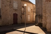 Фонарный столб на улице Старого города с солнечным светом — стоковое фото