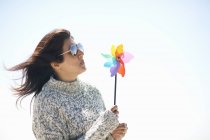 Woman wearing sunglasses holding pinwheel — Stock Photo