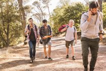 Homme parlant sur smartphone en randonnée avec des amis en forêt, Deer Park, Cape Town, Afrique du Sud — Photo de stock