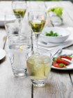 Comida y bebida en la mesa en la fiesta del jardín de verano - foto de stock