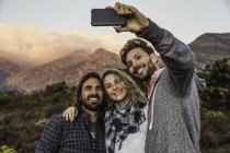Amis à flanc de colline prenant selfie — Photo de stock