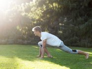 Young man exercising outdoors, stretching — Stock Photo
