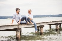 Ältere männliche Freunde entspannen auf Seebrücke — Stockfoto