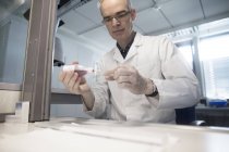 Météorologue masculin préparant la glissière de microscope dans le laboratoire de station météorologique — Photo de stock