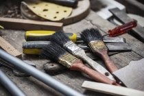 Різноманітність пензлів та інструментів для фарби на дерев'яному столі — стокове фото