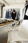 Designer de moda na sala de amostra trabalhando na mesa — Fotografia de Stock