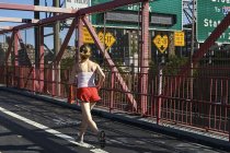 Mujer joven haciendo ejercicio al aire libre, corriendo, vista trasera - foto de stock