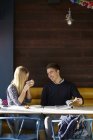 Молода пара на побаченні в кафе п'є каву і читає журнал — стокове фото