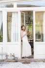 Mujer de pie en la puerta sosteniendo pastel - foto de stock