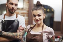 Hairdressers in barber shop looking at camera smiling — Stock Photo