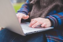 Молода жінка використовує ноутбук, на відкритому повітрі, крупним планом — стокове фото