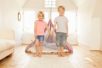 Ritratto di ragazzo e ragazza che si tengono per mano davanti alla tenda della camera da letto — Foto stock
