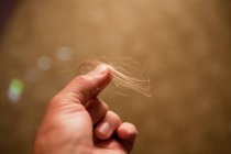 Bambino che tiene pezzi di capelli biondi — Foto stock